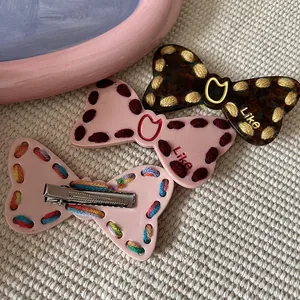 Handmade stitched bow hair clips set with Y2K cat-ear logo and metallic duckbill clip