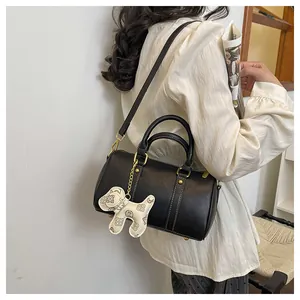 Black Boston pillow bag with a decorative dog-shaped monogram charm