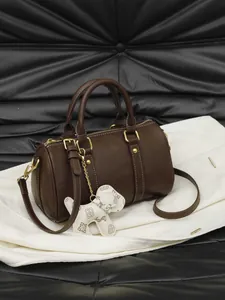 Elegant dark brown women's Boston pillow handbag with dog charm and gold accents