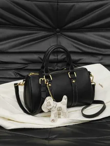 Elegant black Boston pillow handbag with decorative dog charm and crossbody strap for women