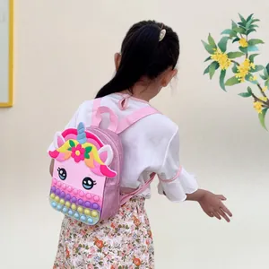 Little girl wearing a pink unicorn backpack for kids featuring colorful pop-it fidget toy panel