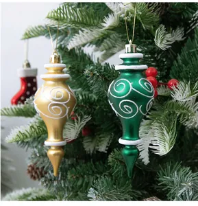 Close-up of gold and green gourd-shaped Christmas tree ornaments with white swirl patterns