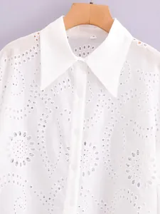 Elegant white embroidered blouse with floral eyelet patterns and classic pointed collar