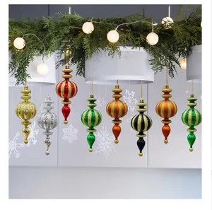 Assorted colorful painted tapered Christmas ornaments hanging from a festive garland with lights