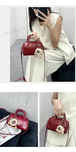 Close-up of stylish red leather Boston pillow bag featuring a cute fluffy sheep charm
