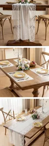 Detail of white French lace table runner and matching placemats on wooden table