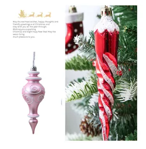 Detailed view of red spiral and pink gourd Christmas tree ornaments with glitter