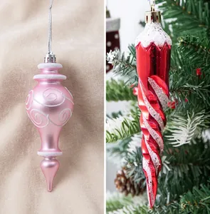 Vista detallada de adornos navideños en espiral rojo y calabaza rosa con purpurina