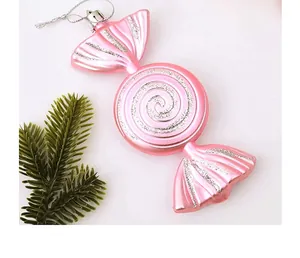 Vista detallada de adorno navideño rosa en forma de caramelo con purpurina plata