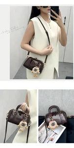 Detail view of retro brown Boston pillow bag featuring a cute plush charm