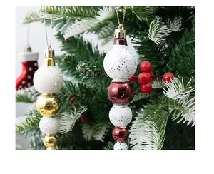 Detail of glittering gourd-shaped Christmas ball ornaments hanging on a festive tree