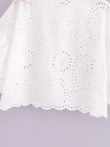 Close-up of white broderie anglaise fabric with intricate eyelet floral patterns