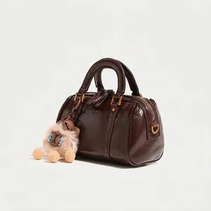 Glossy dark brown Boston pillow handbag for women with cute plush charm