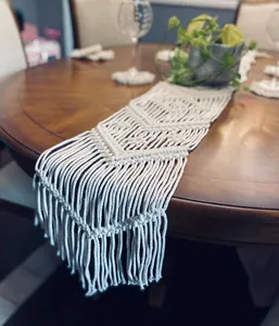 Detailed view of handmade boho macrame table runner with fringe on wooden table