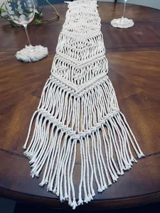 Close-up detail of hand-woven boho macrame table runner with elegant fringe tassels