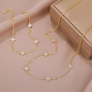 Detailed macro view of 18K gold clover station necklace with sparkling zircon elements.