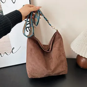 Elegante bolso hobo de ante marrón con una correa ancha con motivos étnicos retro