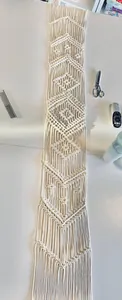Detailed texture of handwoven geometric patterns on a bohemian macrame runner