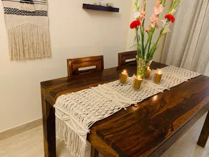 Elegant bohemian handwoven macrame table runner with tassels on a dark wood dining table