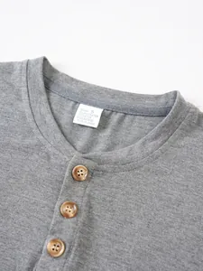 Close-up of grey men's Henley T-shirt collar with buttons and fabric care label
