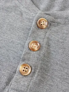 Detailed macro view of three brown marbled buttons on a grey heather men's casual t-shirt