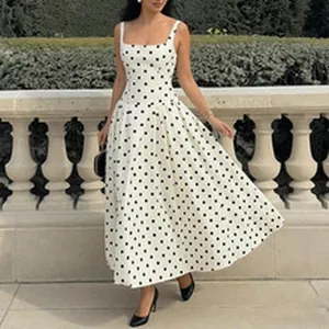 Full-body shot of a model wearing a polka dot maxi dress in a classic garden setting