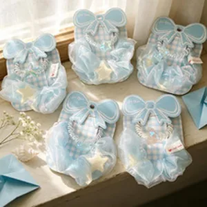 Detail showing 5 light blue organza scrunchies with star charms on gift cards
