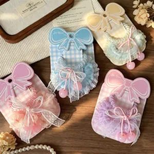 Close-up of cute lace hair ties in pastel pink, blue, and purple with cherry bead charms.