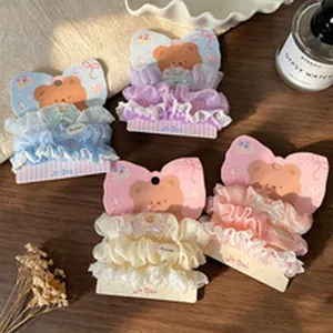 Detailed shot of various pastel colored ruffled hair scrunchies on bear cards