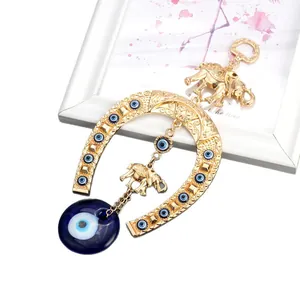 Golden elephant horseshoe pendant keychain with blue evil eye beads charm.