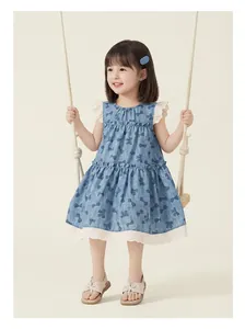 Detailed view of girl's bow print dress with lace trim on a young child model