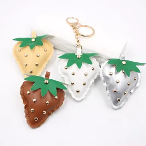 Collection of punk style leather strawberry keychains with gold metal studs.