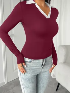 Detail of burgundy long sleeve top featuring a white polo collar and V-neckline.