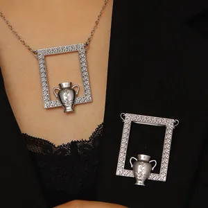 Close-up of artistic silver frame brooch with vase design on a black blazer