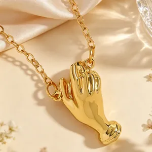 Detailed close-up of a creative gold hand-shaped brooch pin with artistic design