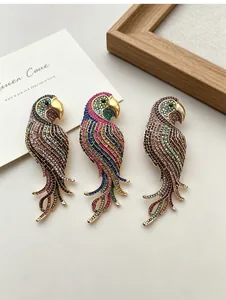 Close-up of three vintage style parrot brooches with multi-colored rhinestone details