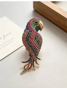Close-up of a vintage parrot brooch with vibrant multi-colored rhinestones on gold base.