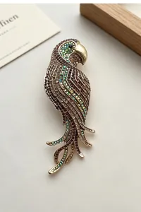 Detail view of a vintage multi-colored crystal parrot brooch on a gold-tone base.