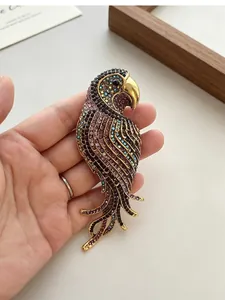 Macro view of vintage parrot brooch with vibrant colorful rhinestones held in a hand