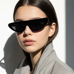 Professional close-up of stylish irregular black cat-eye sunglasses on a fashion model