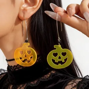 Detailed shot of spooky Halloween pumpkin earrings in neon green and orange colors