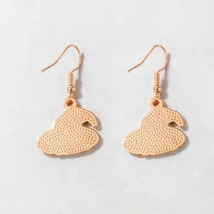 Detailed macro view of rose gold witch hat drop earrings featuring textured dotted pattern
