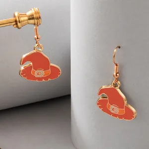 Close-up of orange witch hat Halloween earrings with gold-plated hooks on grey background