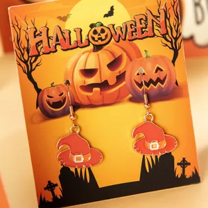 Detailed shot of orange witch hat enamel earrings on a festive Halloween display card