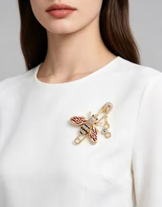 Detailed view of a crystal-paved enamel bee brooch with a honeycomb charm on a model