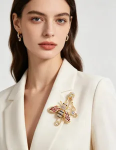 Elegant crystal bee brooch with red enamel wings pinned to a white blazer lapel for styling