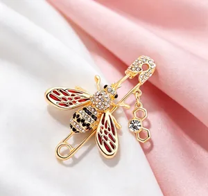 Detailed close-up of a sparkling bee brooch with red oil dripping and rhinestones