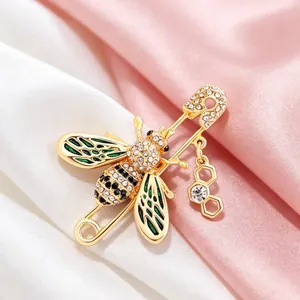 Luxury gold bee brooch pin with sparkling crystals and green enamel details