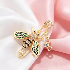 Elegant gold bee safety pin brooch with sparkling rhinestones and green enamel wings.