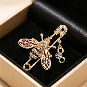 Elegant gold honeybee brooch pin with red enamel wings and sparkling crystals